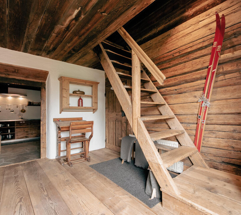 Historische Holztreppe unter der Holzbalkendecke im Chalet