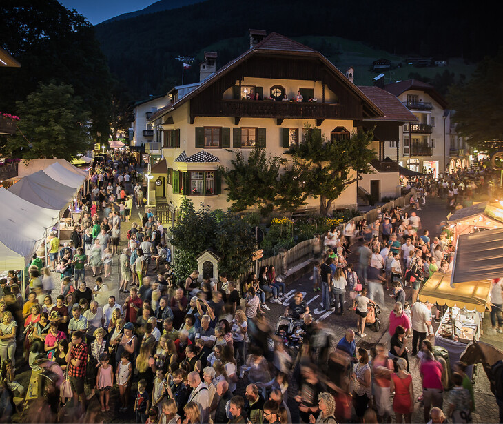 Große Menschenmenge in einem Dorf bei Abenddämmerung.