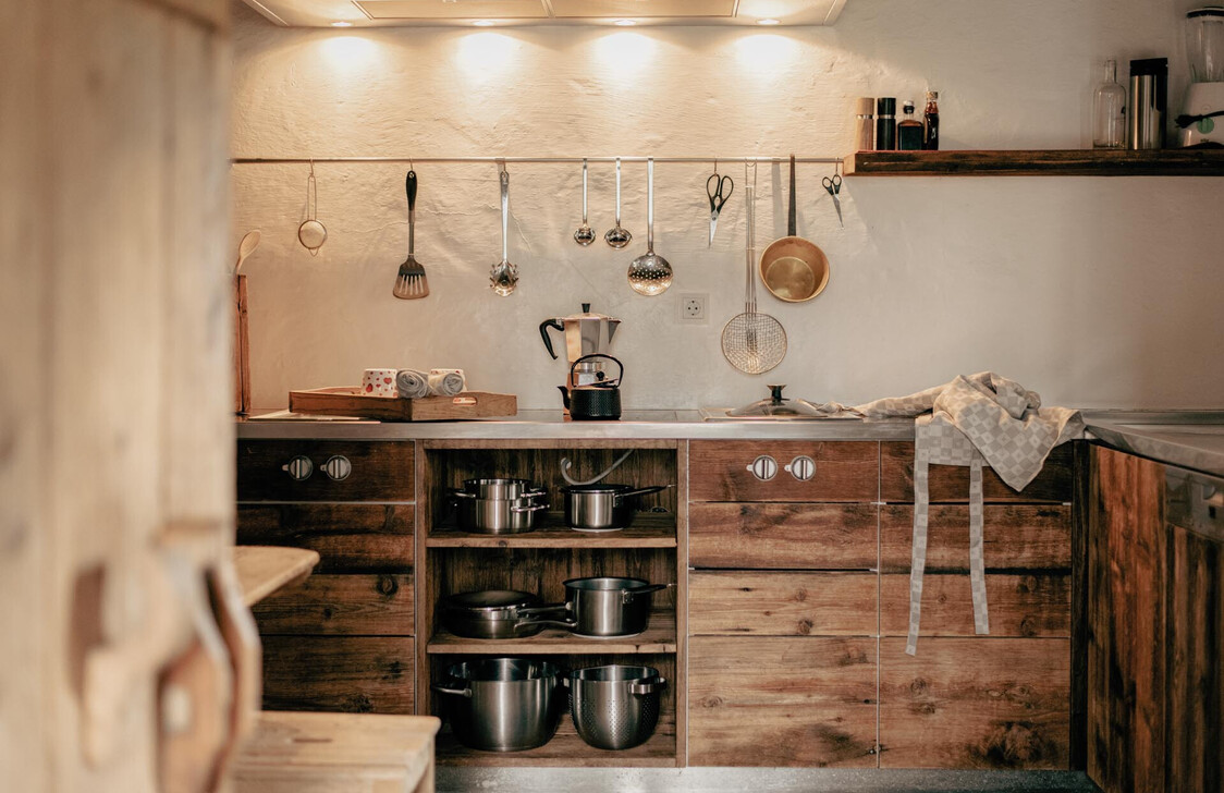 Rustikale Chalet-Küche mit Holzfronten und traditionellen Küchenutensilien